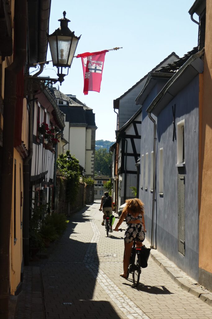 Radfahrende Menschen in einer Gasse in Königswinter